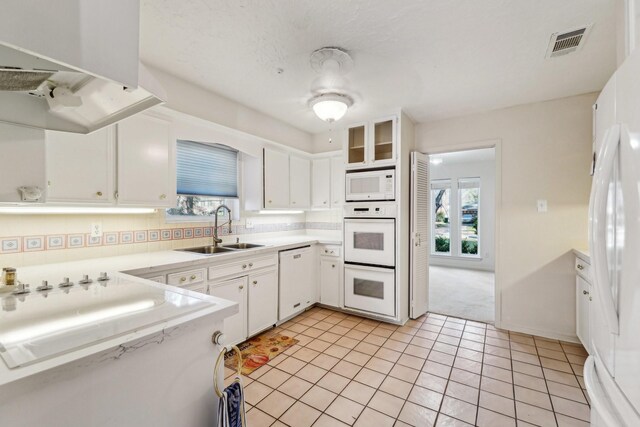 kitchen featuring light tile patterned floors, sink, white appliances, and white cabinets