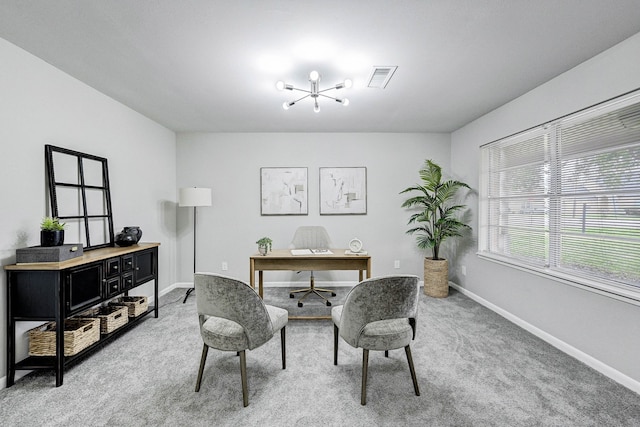 carpeted home office featuring a notable chandelier