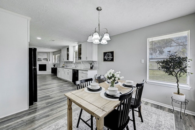 dining room with a textured ceiling, a wealth of natural light, and a notable chandelier