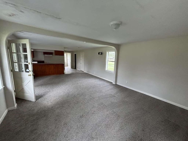 unfurnished living room with dark colored carpet