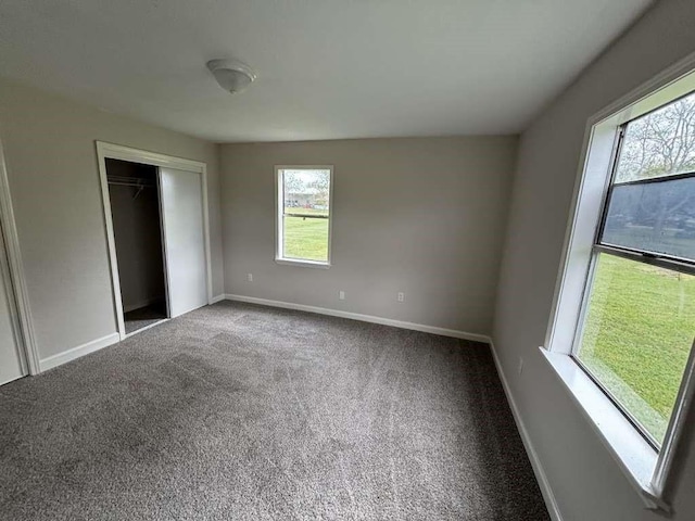 unfurnished bedroom with carpet, a closet, and multiple windows