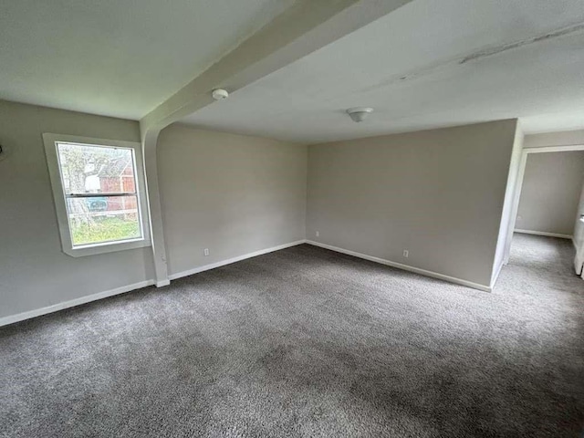 spare room with carpet flooring and beam ceiling