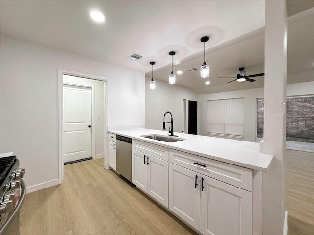 kitchen featuring pendant lighting, white cabinetry, stainless steel appliances, sink, and light hardwood / wood-style flooring