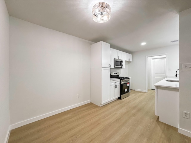 kitchen featuring light hardwood / wood-style floors, sink, white cabinetry, and stainless steel appliances