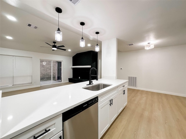 kitchen with white cabinets, decorative light fixtures, sink, stainless steel dishwasher, and light hardwood / wood-style flooring