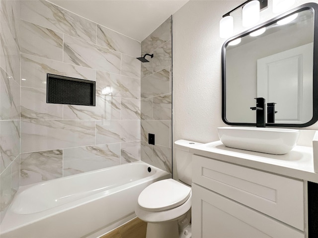 full bathroom featuring toilet, tiled shower / bath, vanity, and hardwood / wood-style floors