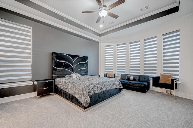 carpeted bedroom featuring ceiling fan, crown molding, and a raised ceiling