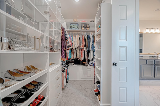 spacious closet with light carpet and sink