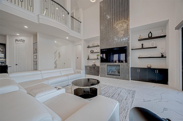 living room featuring a towering ceiling and a tile fireplace