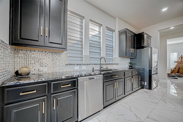 kitchen featuring decorative backsplash, sink, stainless steel appliances, and dark stone countertops