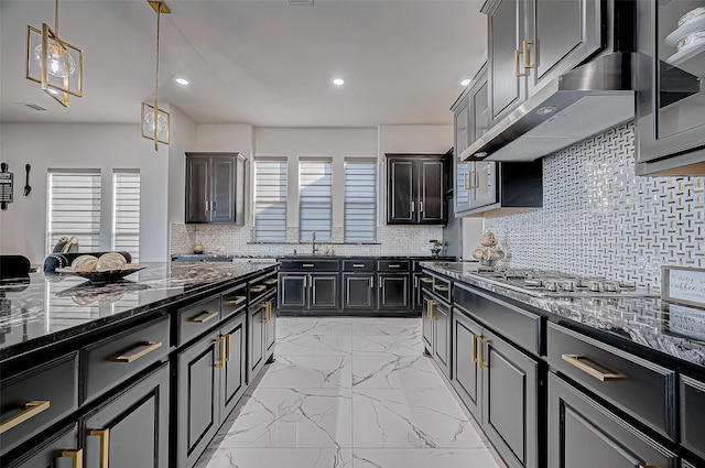 kitchen featuring decorative backsplash, pendant lighting, dark stone countertops, and plenty of natural light