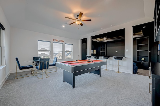 recreation room with ceiling fan, light colored carpet, a tray ceiling, and billiards