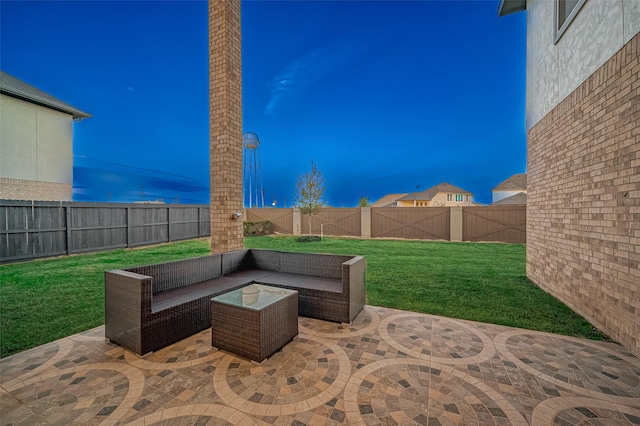 patio terrace at dusk with outdoor lounge area and a lawn