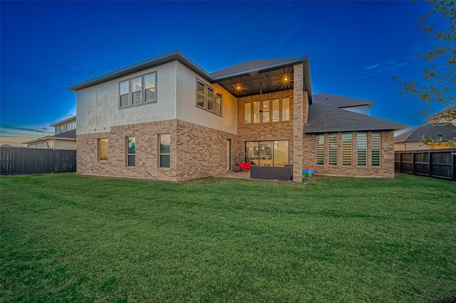 back house at dusk with an outdoor hangout area and a lawn