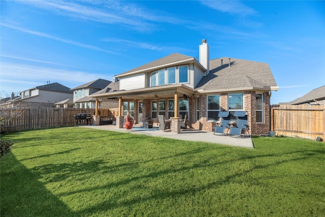 back of house featuring a lawn and a patio