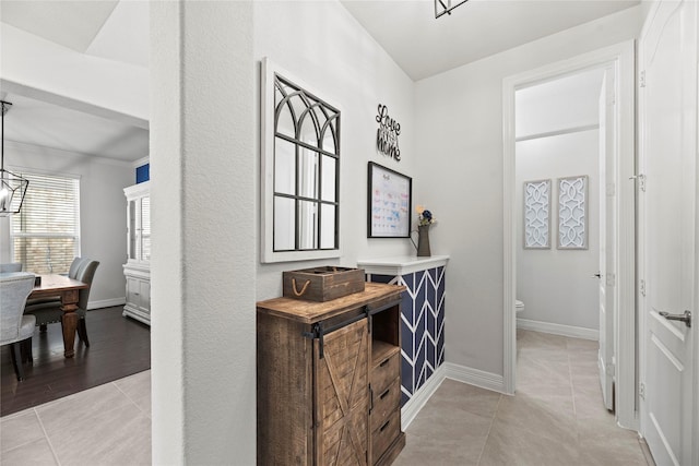 hall with light tile patterned flooring and ornamental molding