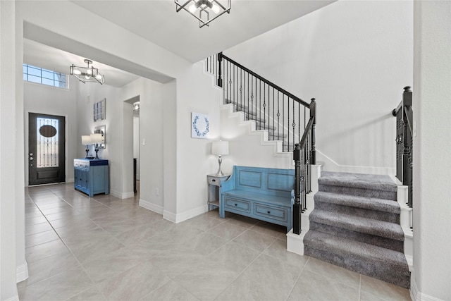 tiled foyer entrance featuring a notable chandelier