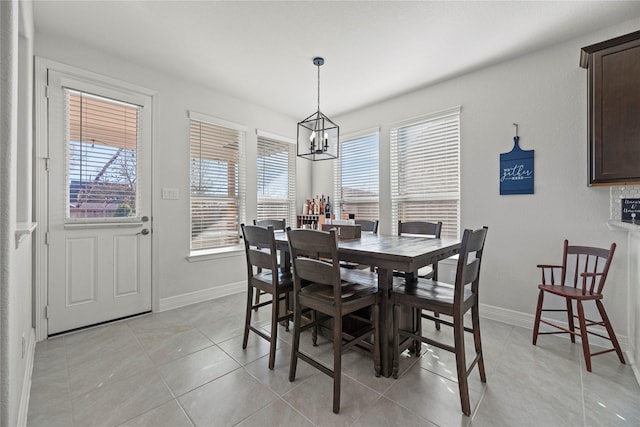 tiled dining space featuring an inviting chandelier and plenty of natural light