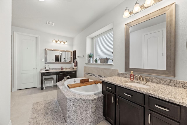 bathroom with tiled bath, tile patterned floors, and vanity