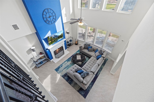 living room with ceiling fan and a high ceiling