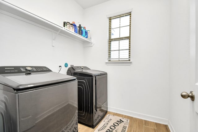 laundry area with light wood-type flooring and washing machine and dryer