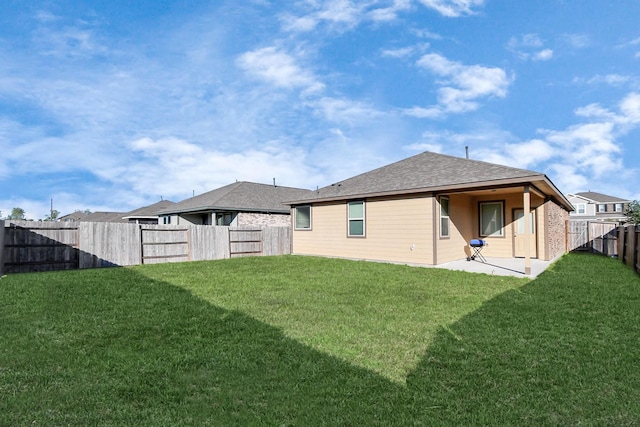 rear view of property featuring a patio area and a yard