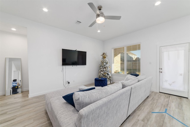 living room featuring ceiling fan and light hardwood / wood-style flooring