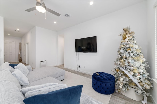 living room featuring ceiling fan and light hardwood / wood-style floors