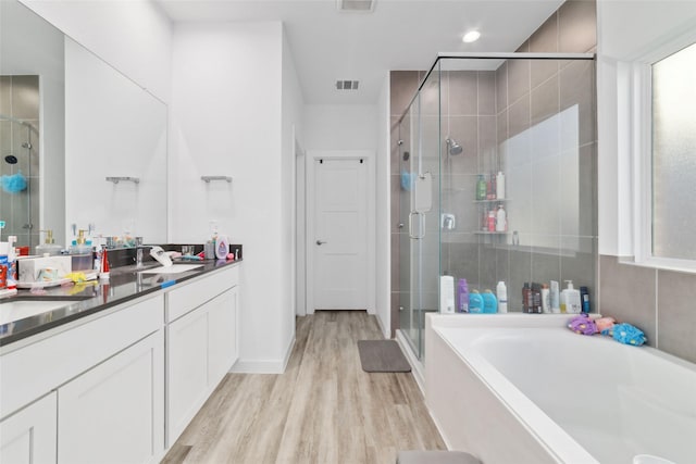 bathroom with vanity, independent shower and bath, and hardwood / wood-style flooring