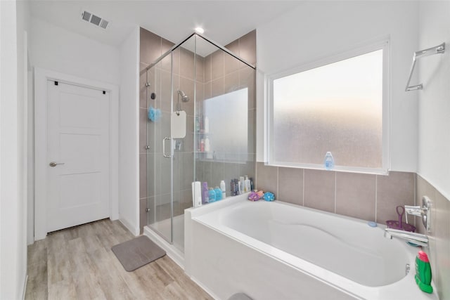 bathroom featuring shower with separate bathtub and hardwood / wood-style flooring