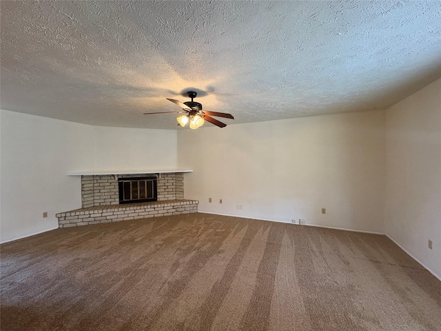 unfurnished living room with a brick fireplace, a textured ceiling, ceiling fan, and carpet flooring