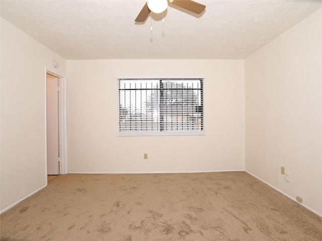 carpeted empty room with ceiling fan and a textured ceiling