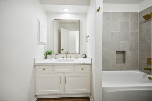 bathroom featuring tiled shower / bath combo and vanity