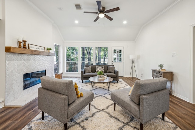 living room with wood-type flooring, lofted ceiling, and a tiled fireplace