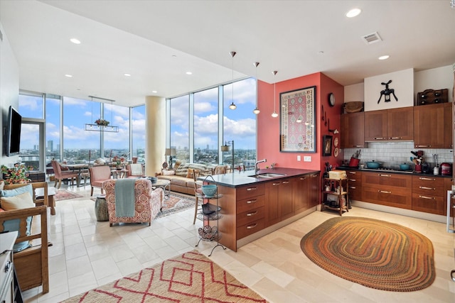 kitchen with expansive windows, kitchen peninsula, and a healthy amount of sunlight