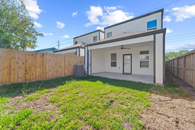 rear view of property featuring ceiling fan, a patio area, cooling unit, and a lawn