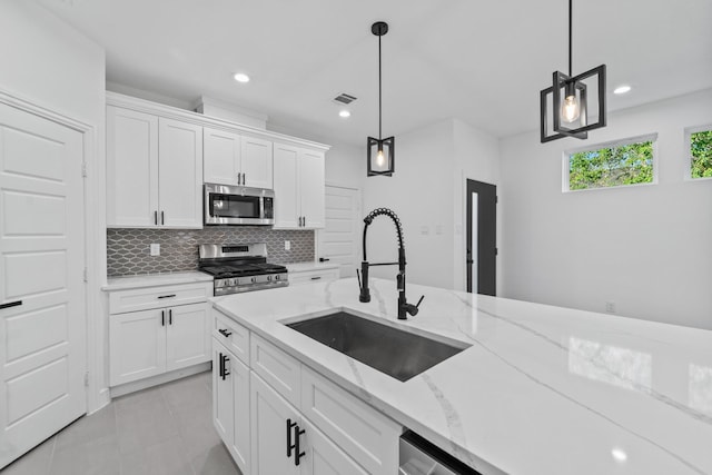 kitchen with stainless steel appliances, white cabinets, hanging light fixtures, and sink