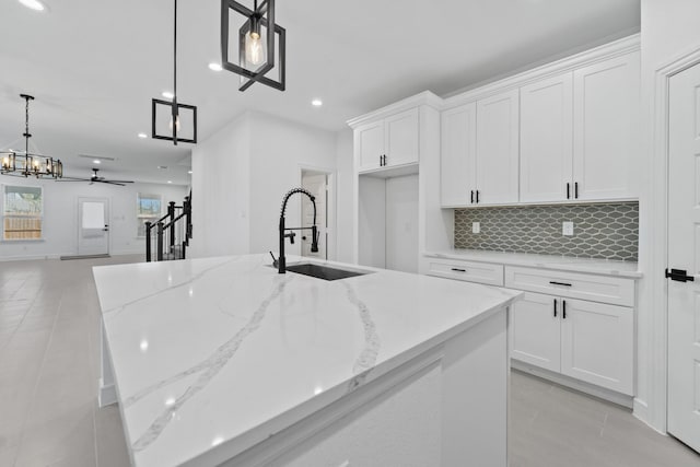 kitchen with white cabinetry, pendant lighting, and sink