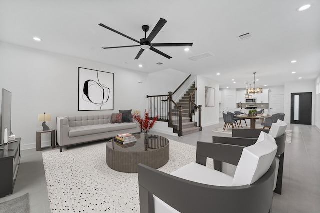 living room with ceiling fan with notable chandelier