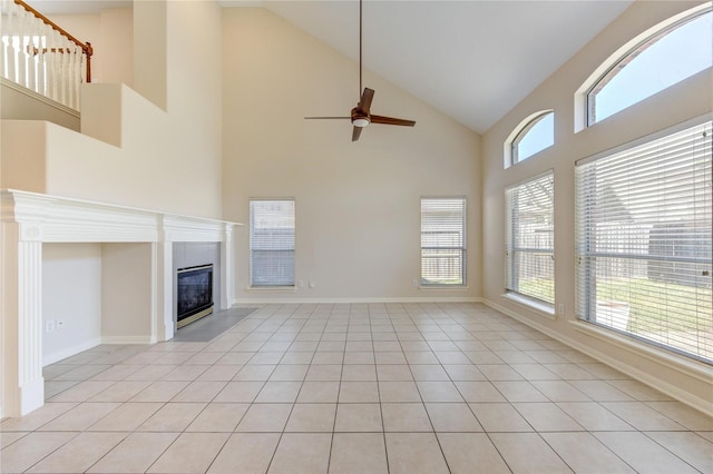 unfurnished living room with high vaulted ceiling, light tile patterned floors, and ceiling fan