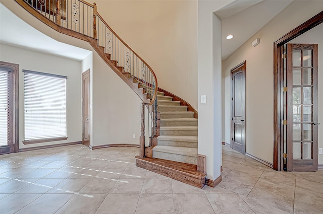 foyer with light tile patterned floors and a towering ceiling