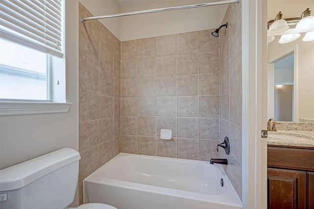 full bathroom with tiled shower / bath, vanity, and toilet