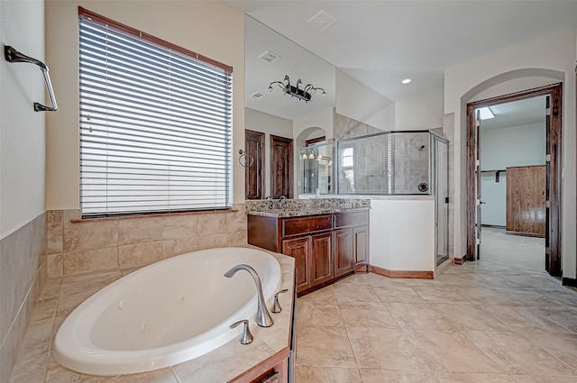 bathroom with vanity and shower with separate bathtub