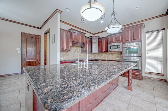 kitchen with a breakfast bar, tasteful backsplash, crown molding, a center island with sink, and stainless steel appliances