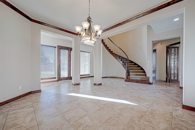 foyer with ornamental molding and a chandelier