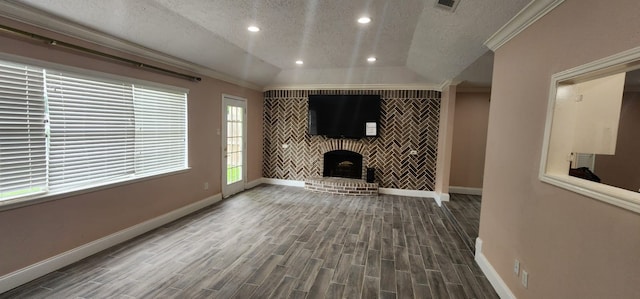 unfurnished living room with lofted ceiling, a fireplace, ornamental molding, and a textured ceiling