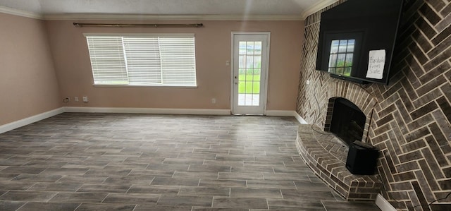 unfurnished living room featuring wood-type flooring, a brick fireplace, and ornamental molding