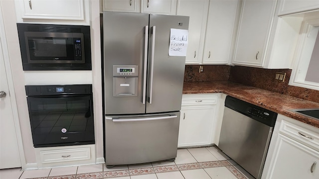 kitchen featuring white cabinets, dark stone counters, light tile patterned floors, and stainless steel appliances