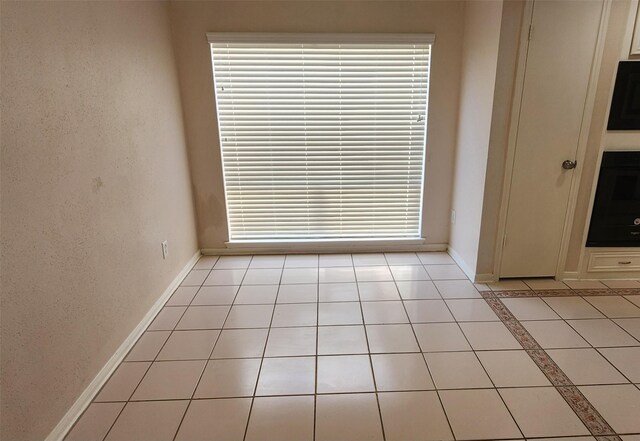 tiled empty room featuring a wealth of natural light