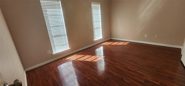 empty room with dark hardwood / wood-style flooring